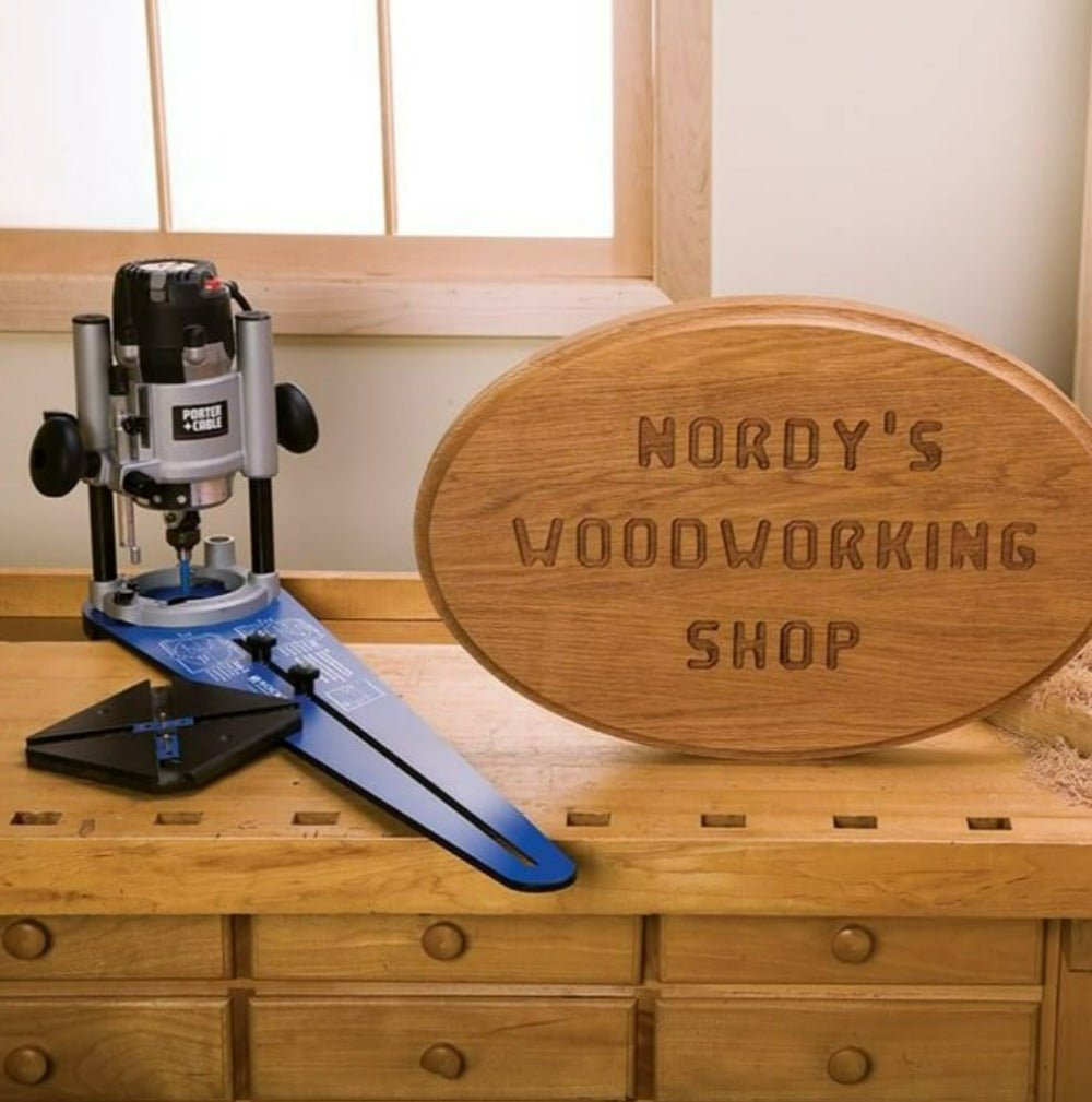 Rockler Ellipse / Circle Router Jig showing the finished sign with router wording and oval shape. Placed on a bench with router attached to the jig.