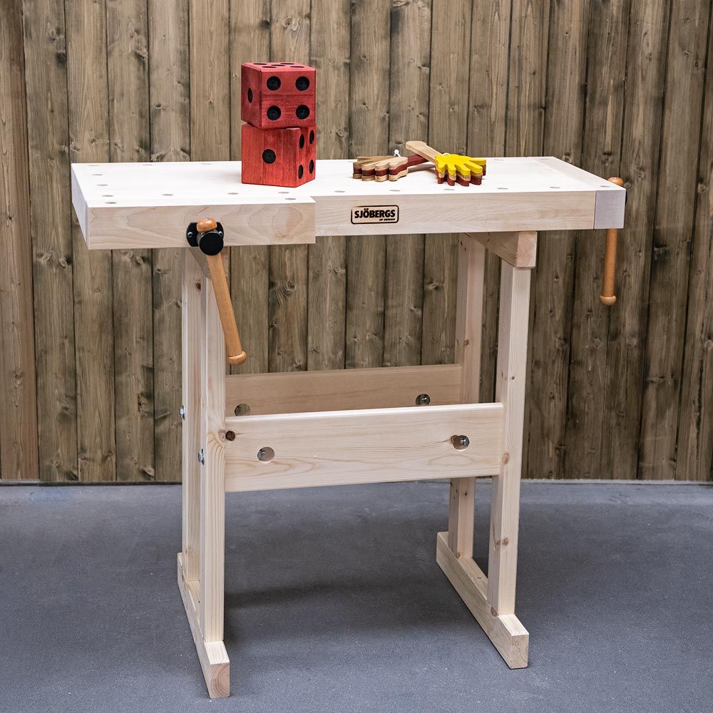 picture of the dual height Sjobergs Adult/Kids Workbench. Has a wooden vice at the end and one on the side. Picture shows to wooden made ornaments