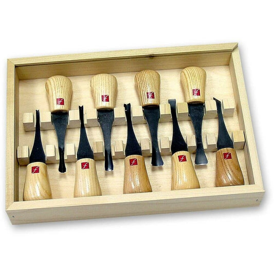 Mixture of 9 knives and gouges placed in a wooden box, each knife spaced with the box in a rack. Box has a sliding lid to enclose the contents.