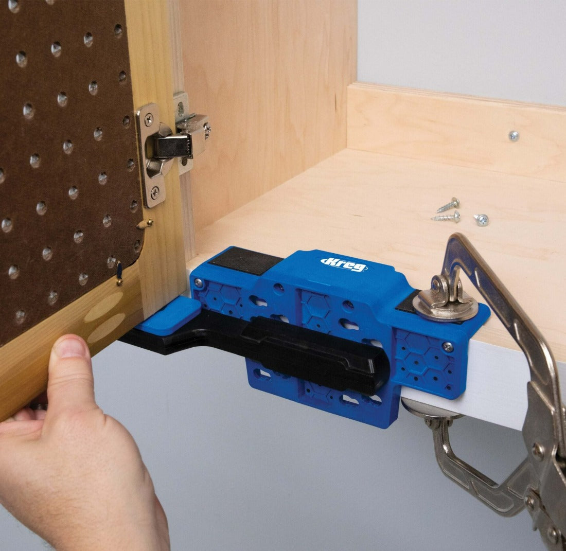 Kreg Cabinet Door Mounting Jig image showing jig is clamped in place and bottom bracket of clamp holding door in place allowing the hinges to be screwed in place