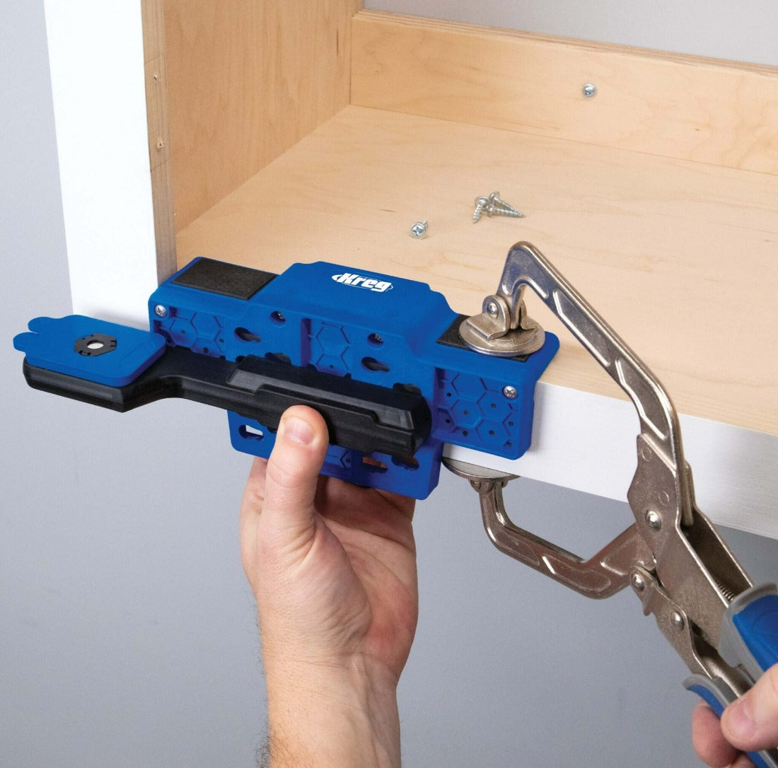 Kreg Cabinet Door Mounting Jig image is showing jig being placed onto the bottom of a wall cabinet and held in place with a 3 inch automaxx clamp