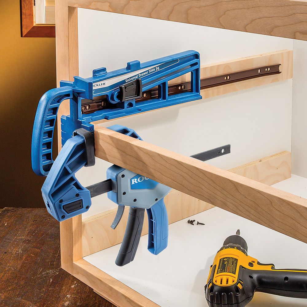 Rockler Universal Drawer Slide Jig in position to attach a drawer runner, using a  F Clamp to secure on cross bar.